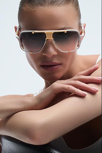Woman wearing stylish sunglasses, posing with arms crossed.