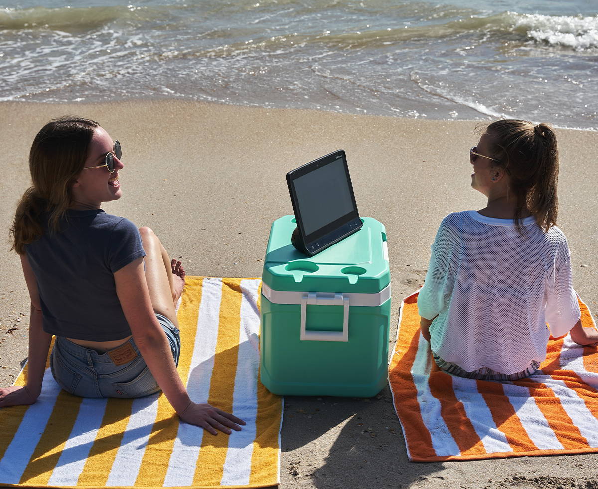 Young woman using her Tobii Dynavox TD I-Series AAC device at the beach