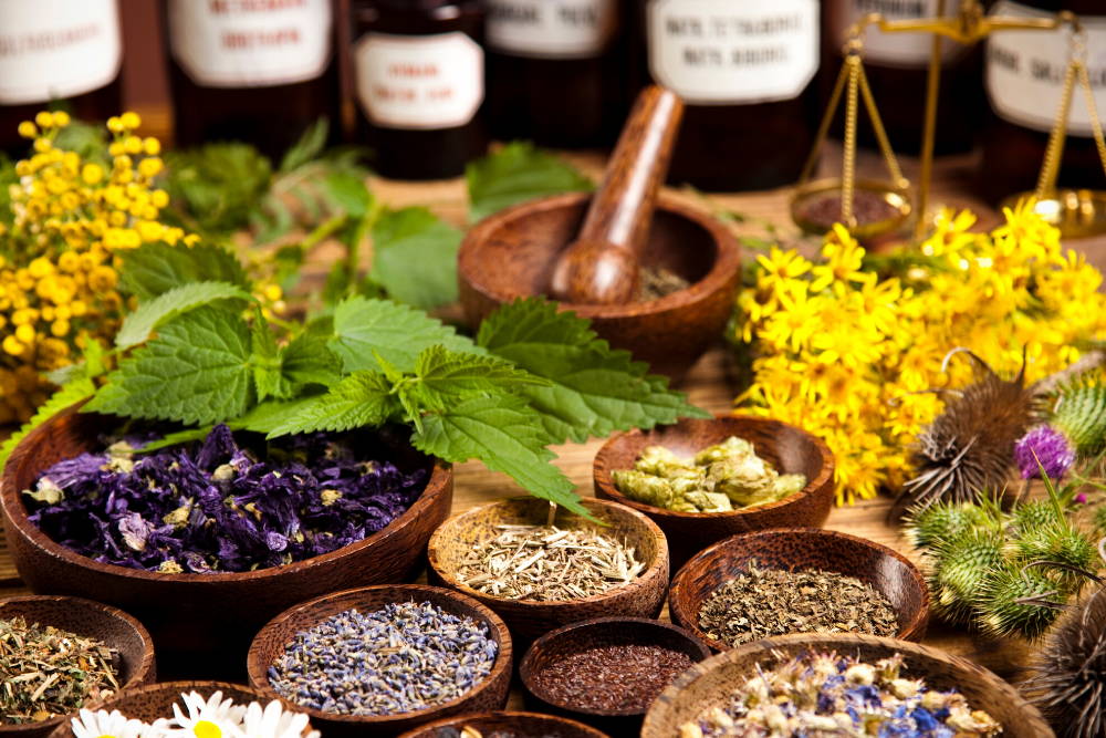 herbs and bottles on wooden table in bowls|build up your natural medicine cabinet