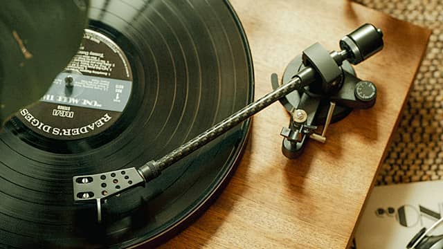 A close-up of a vinyl record and turntable arm.