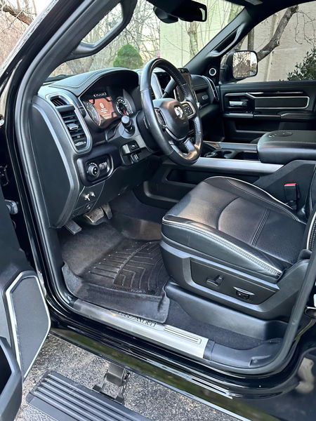 Driver interior of black RAM truck showing custom horn toggle switch on dashboard