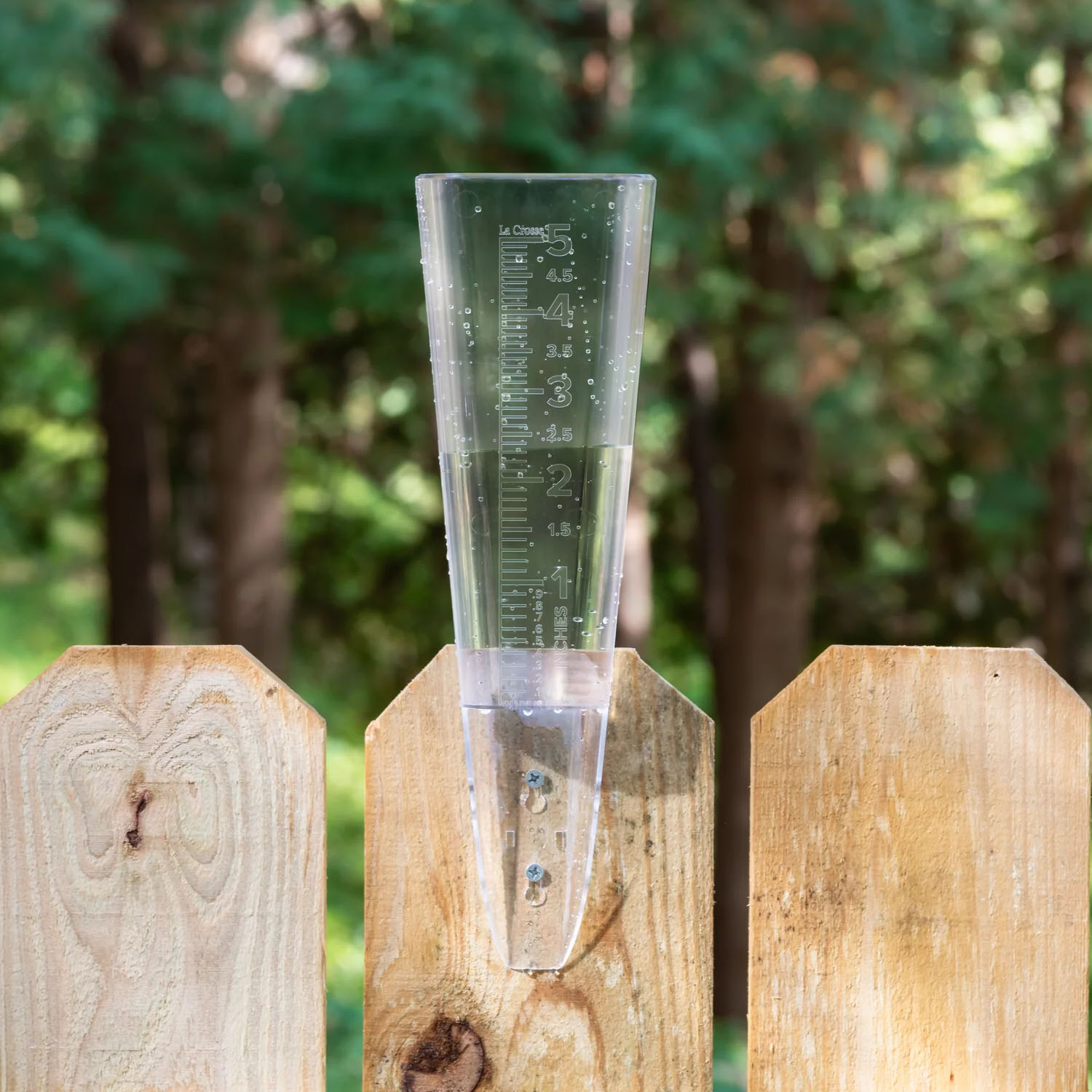 704-5331 rain gauge mounted on a wooden fence.