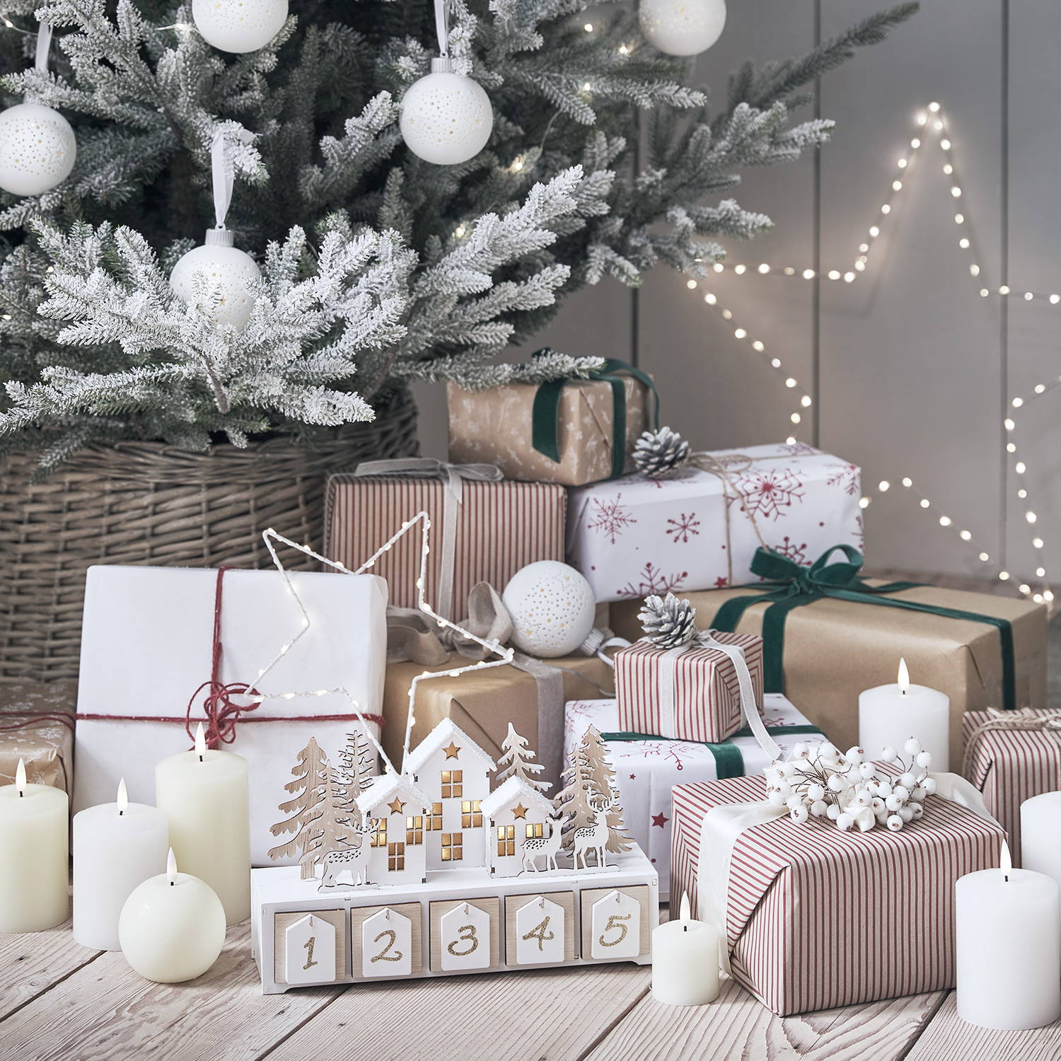 Christmas presents underneath a tree with LED candles, star lights and a wooden advent calendar.