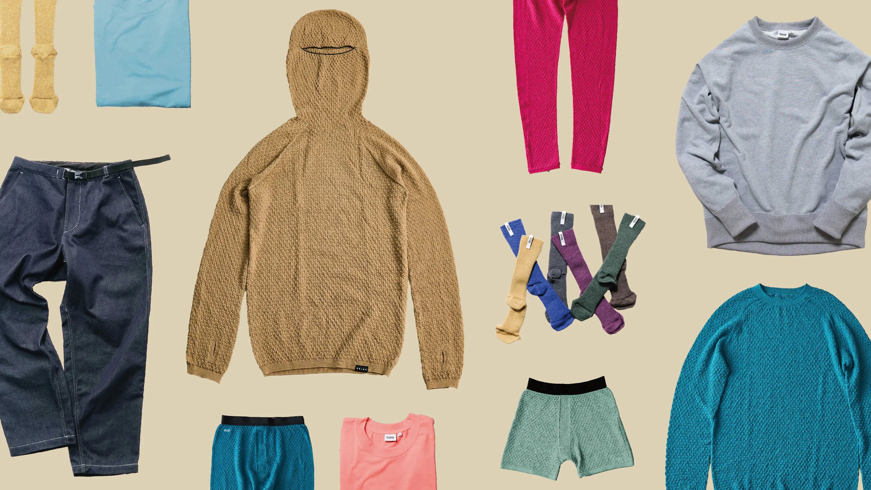 Assorted clothing items laid out on a neutral background.