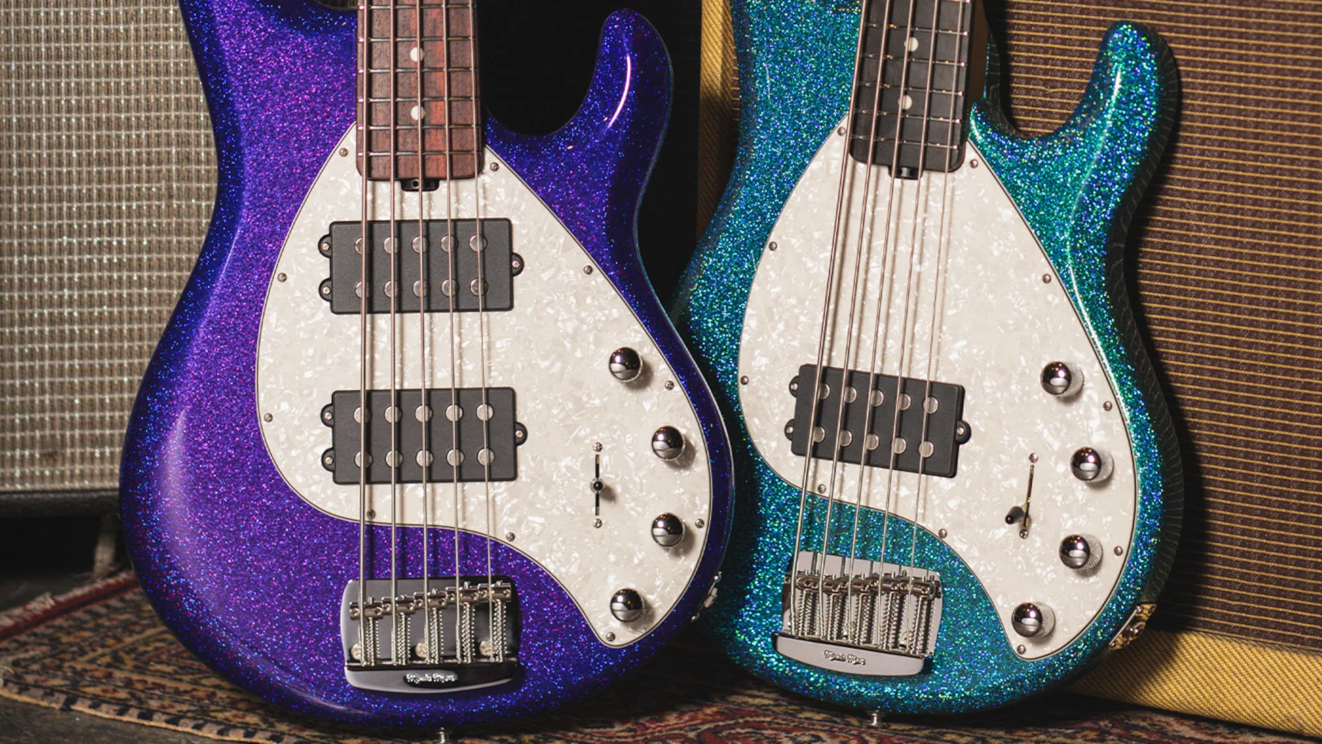 Two Music Man StingRay 5 Special bass guitars in purple and teal colours.