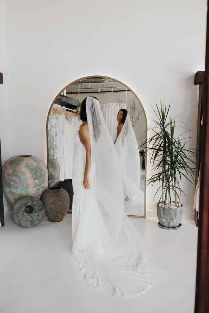 Des femmes essaient un voile de tulle dans notre boutique a Seattle.