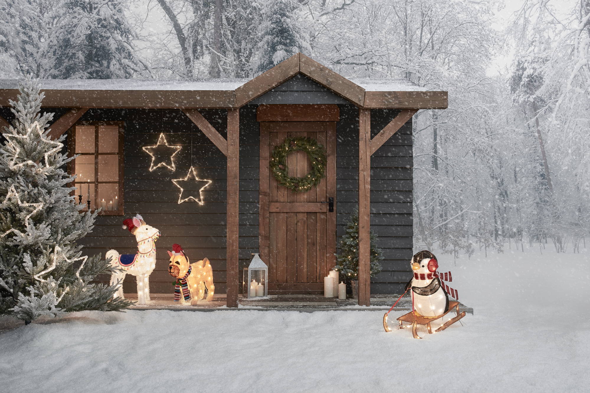 A winter wonderland setting with light up figures around a cottage.