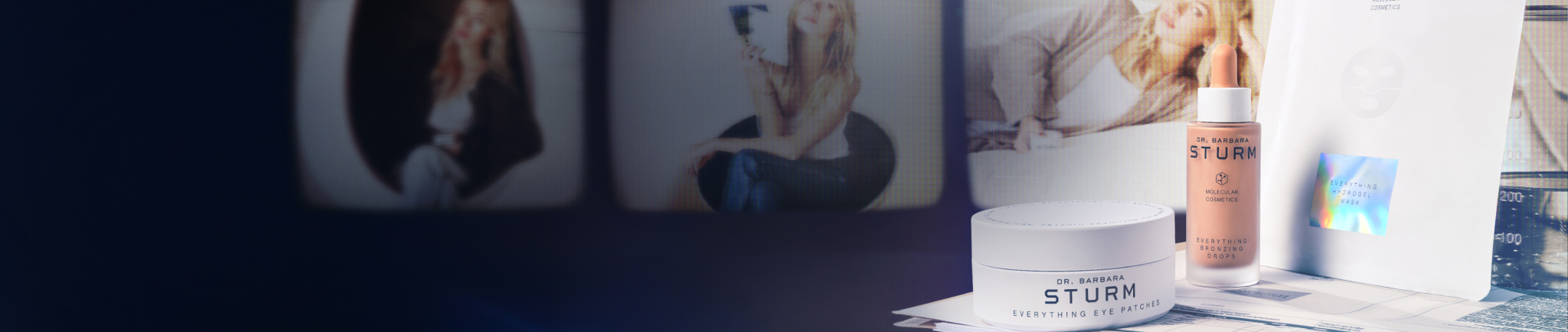 A workspace with photos and documents on a desk against a dark background.
