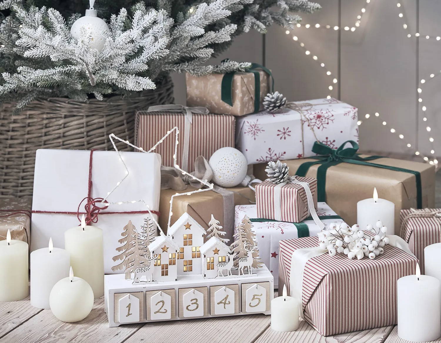 Christmas presents underneath a tree with LED candles, star lights and a wooden advent calendar.