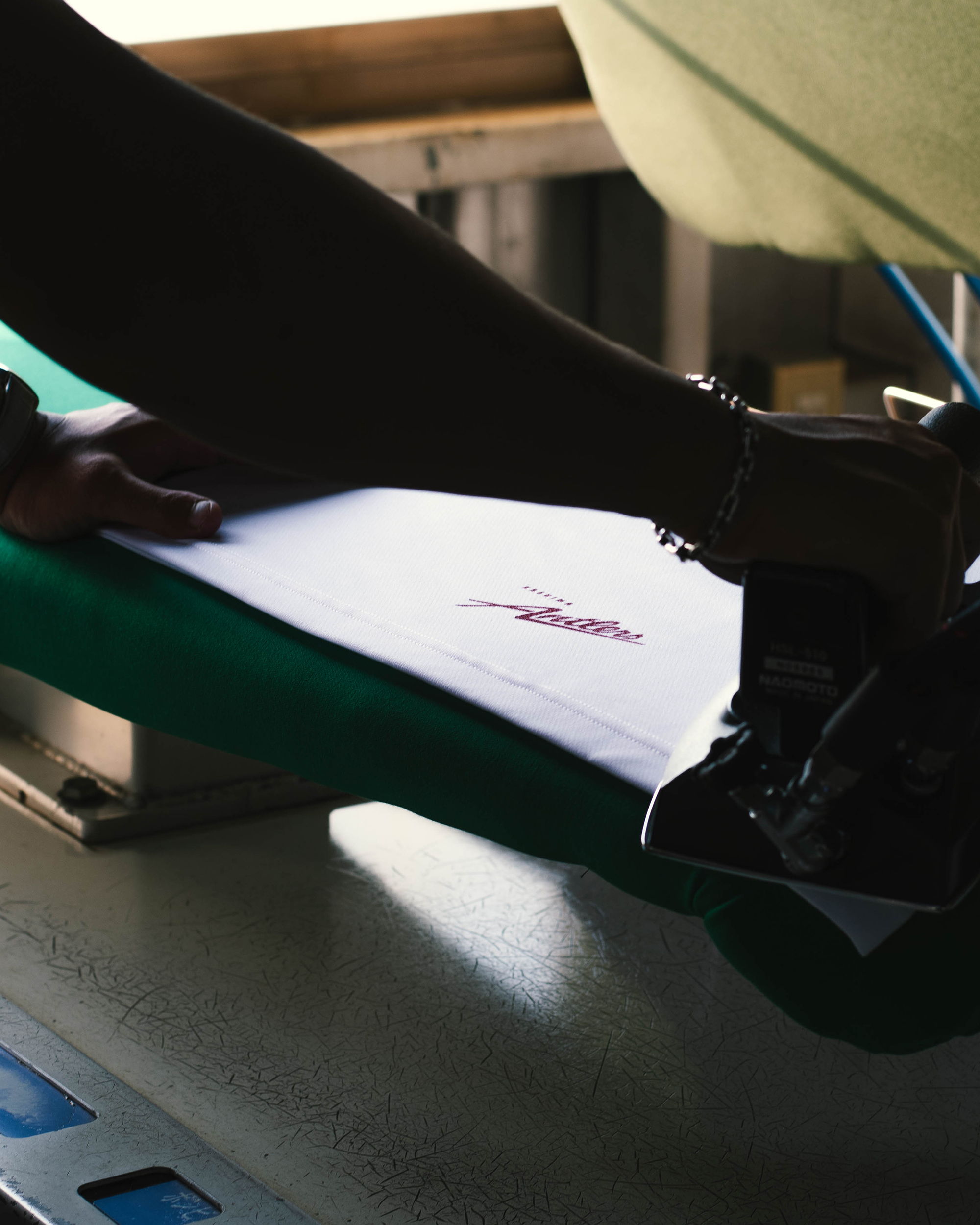 A hand using a stapler on a sheet of paper.