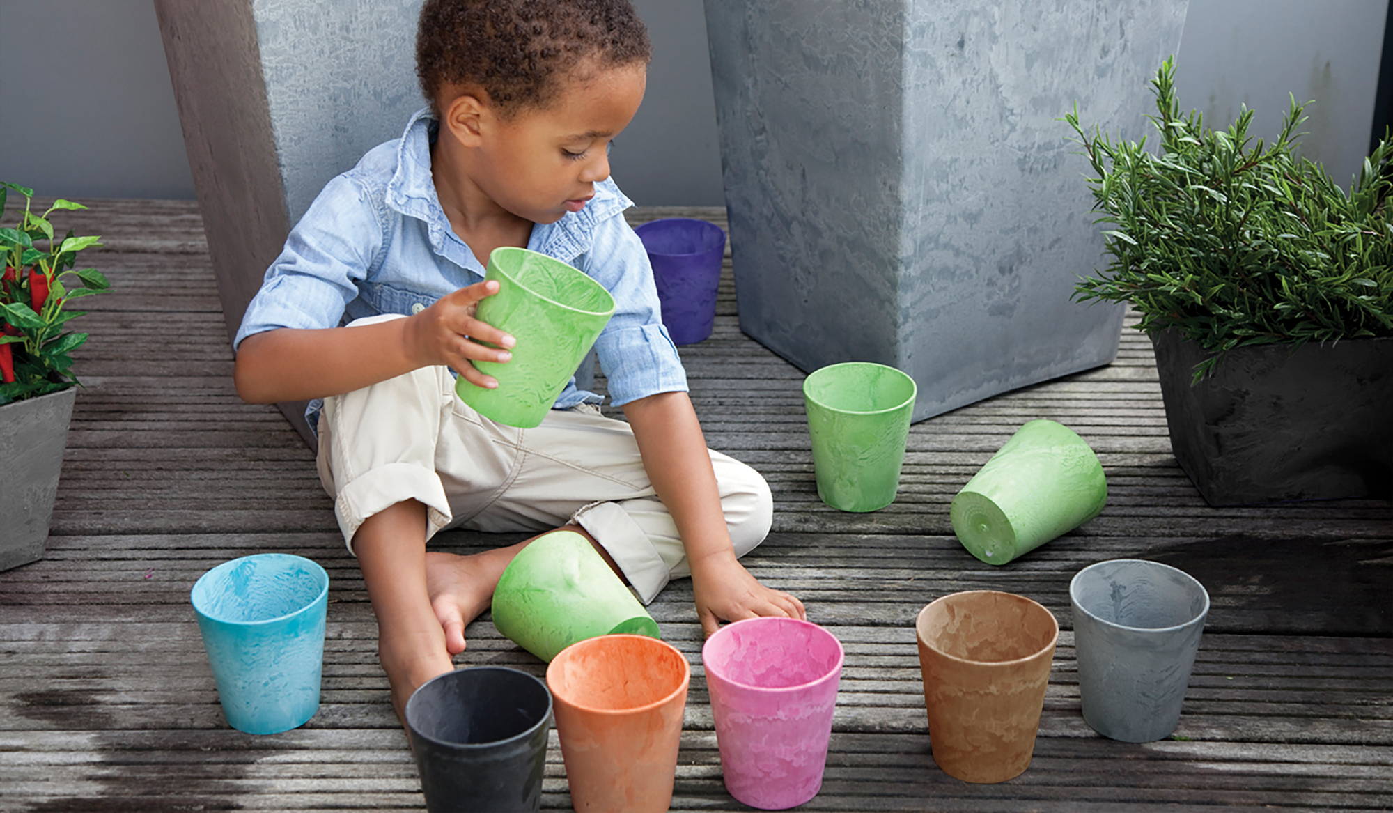 Boy holding Artstone cache pot drop in planter