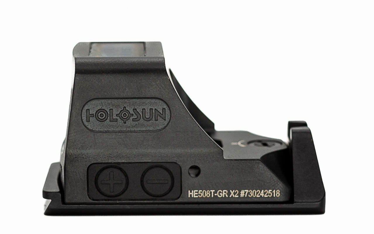 Holographic sight with adjustable base and control buttons, viewed from the side.