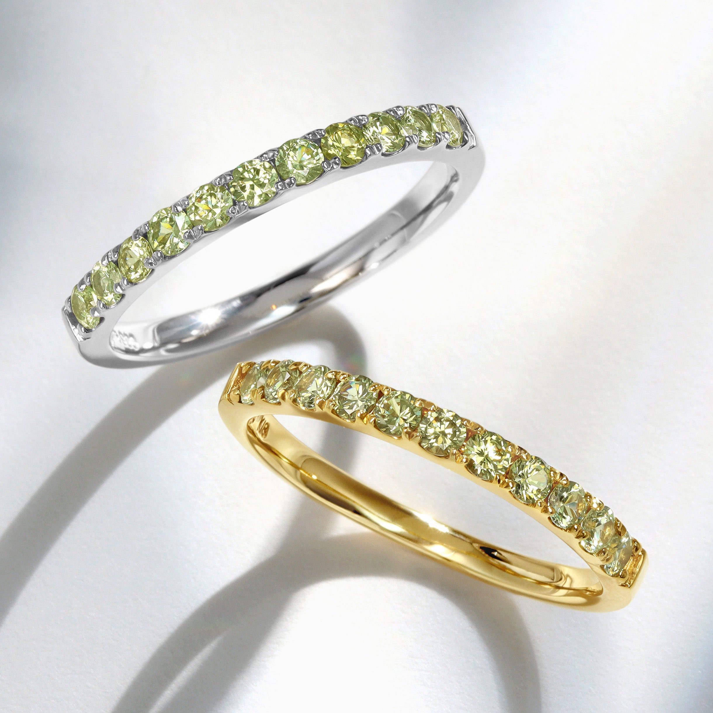 Two rings, one silver and one gold, adorned with yellow gemstones.
