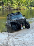 Polaris Xpedition XP5 tilted riverbank sandy shore partially submerged tires wooded river Shane's Compact Electric horn gallery photo 4
