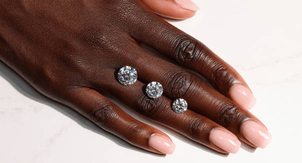 Round cut lab grown diamonds shown sitting on a hand