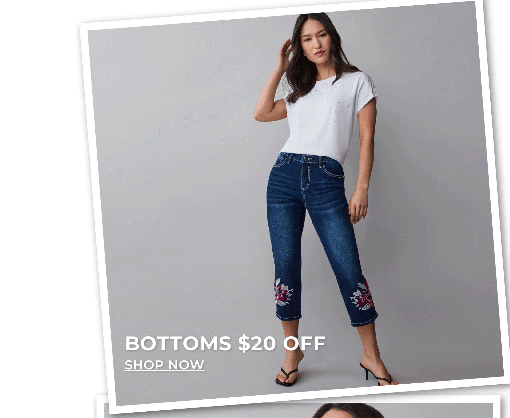 Woman standing in floral embroidered jean capris, bottoms $20 off.