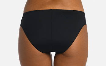 Back image, close-up of model wearing black side shirred hipster swimsuit bottoms.