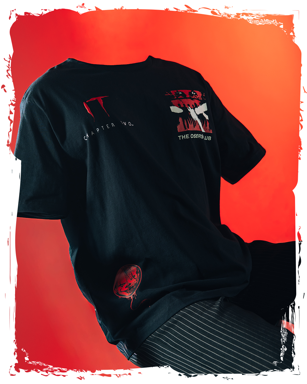 Black t-shirt with graphic designs on a red background.
