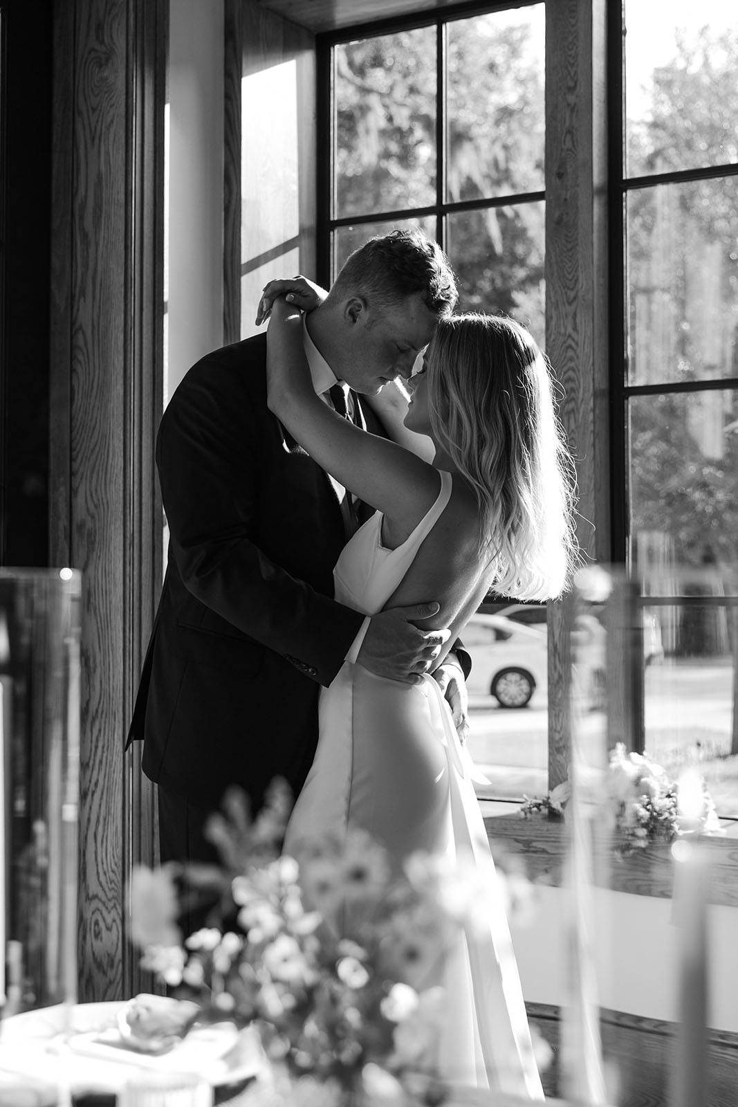 Captivating black and white photograph capturing the bride and groom gracefully dancing, immersed in the timeless magic of their special moment.