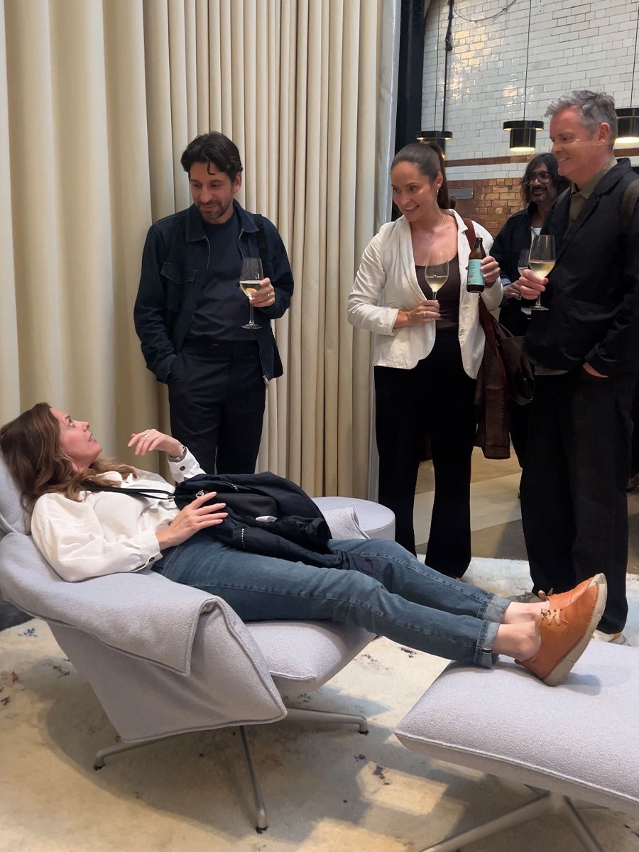 Chaplins team at vitra showroom, one person reclining on a chair, drinks in hand.