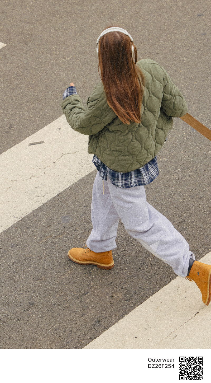 Person in casual clothing walking on a crosswalk.