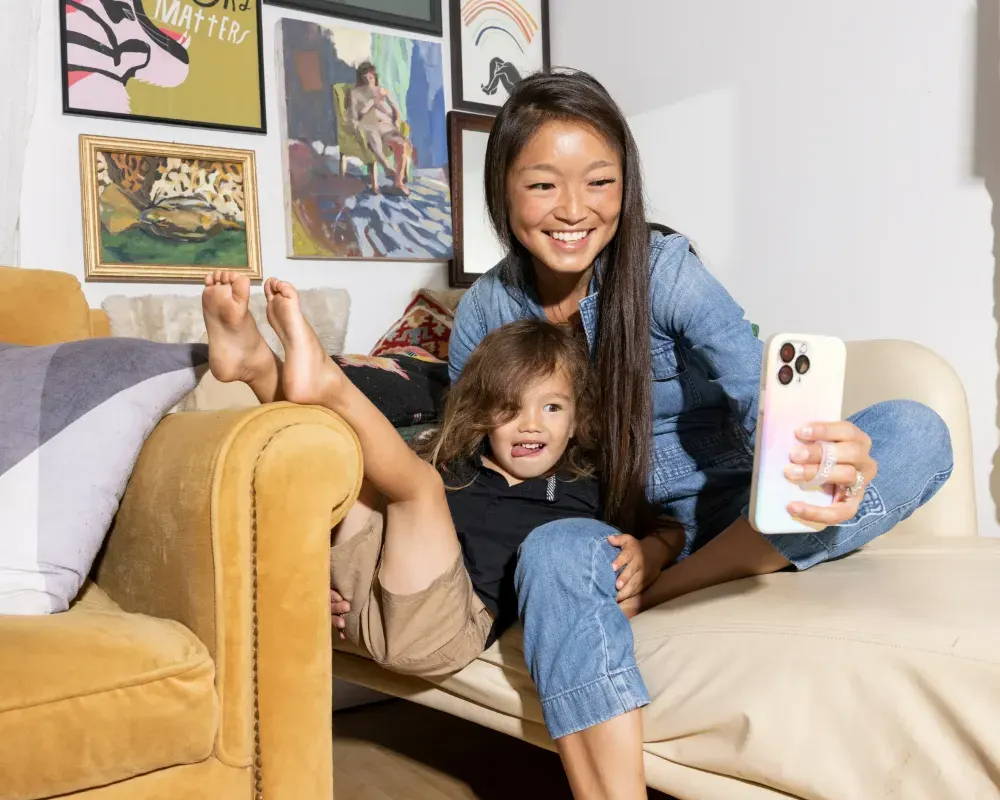 Female entrepreneur taking photos with her son to grow her social media marketing presence