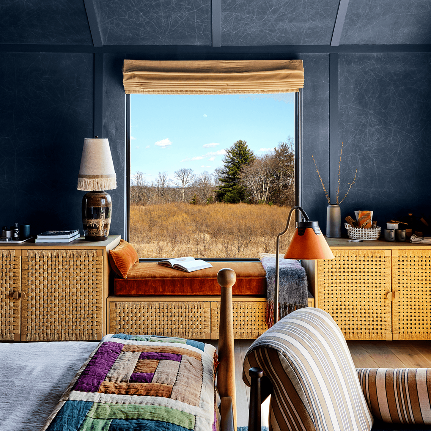 Cozy room with window overlooking a natural landscape.