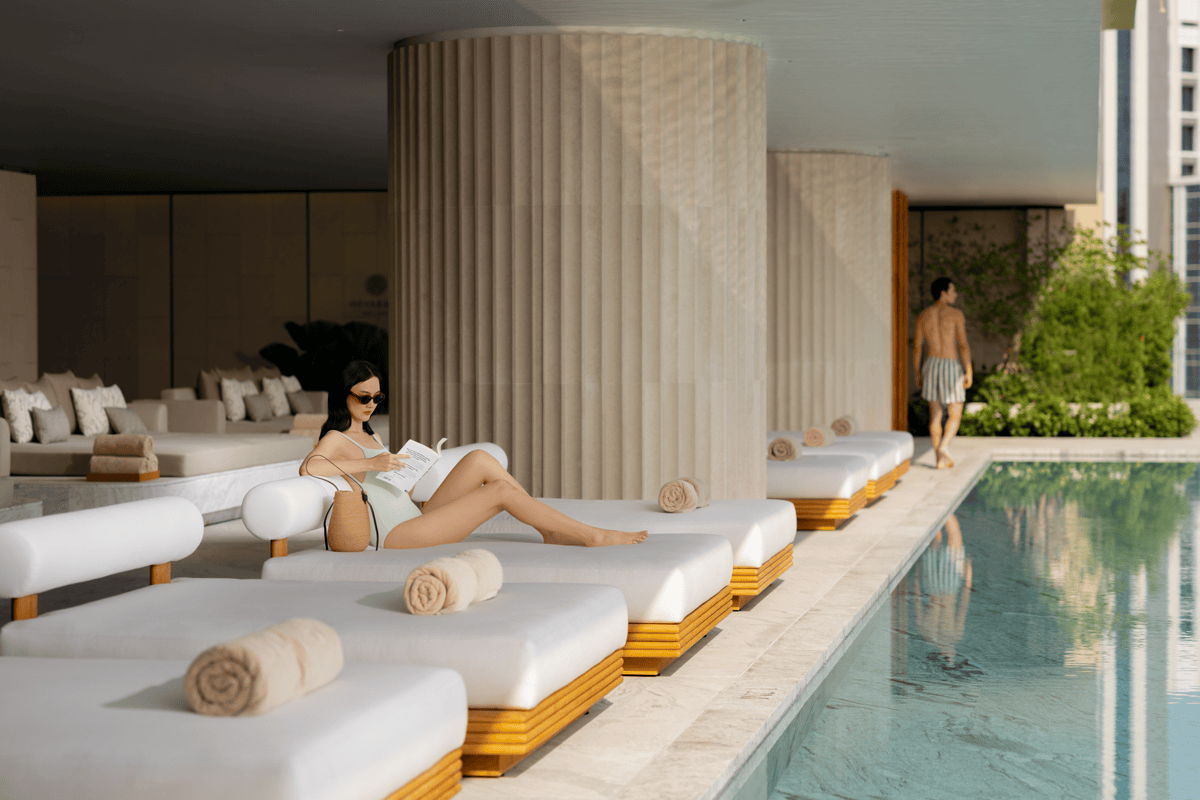 Luxury pool patio design with cushioned poolside chaise lounges, rolled towels, and shaded outdoor seating.