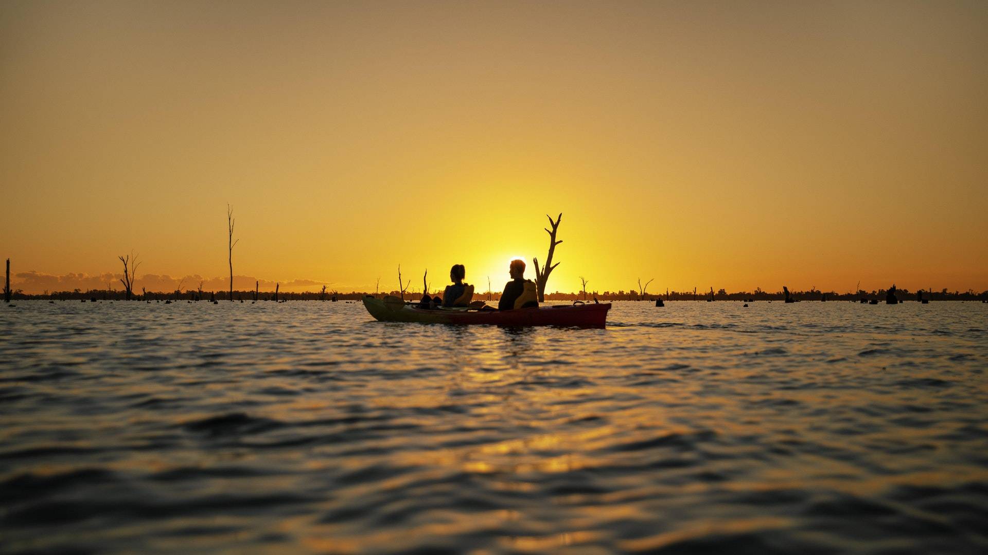 A couple fishing in a kayak on Lake Mulwala at Sunset
