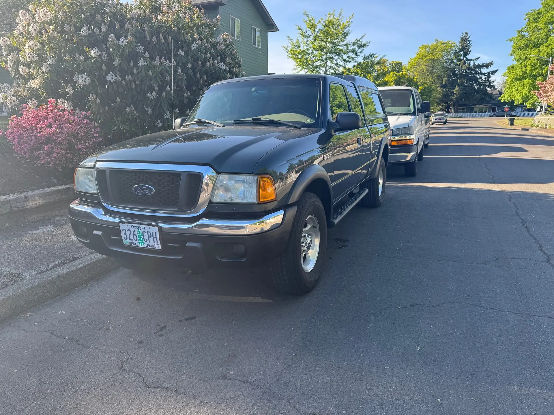 Front three-quarter Joshua's 2005 Ford Ranger dark grey with camper shell parked on residential street photo 1