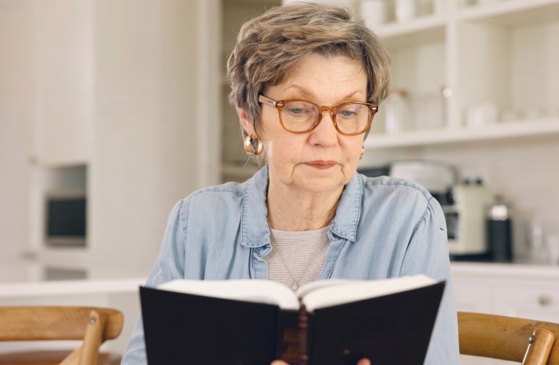 Woman wearing Fierce Brown reading glasses while reading a book