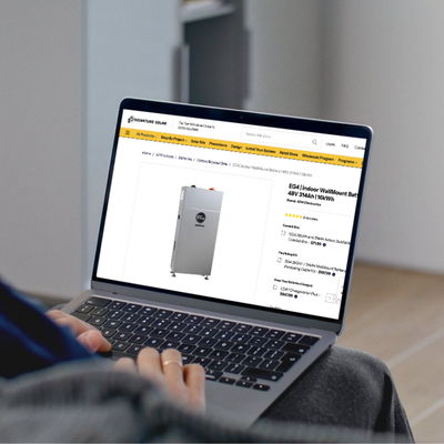 Person using a laptop to view a Signature Solar product page.