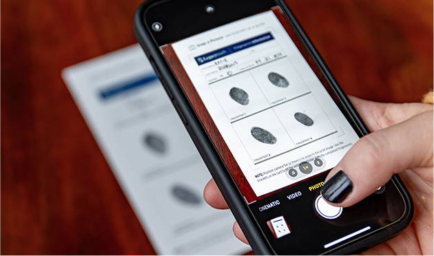 up close view of hand holding cell phone taking picture of fingerprints
