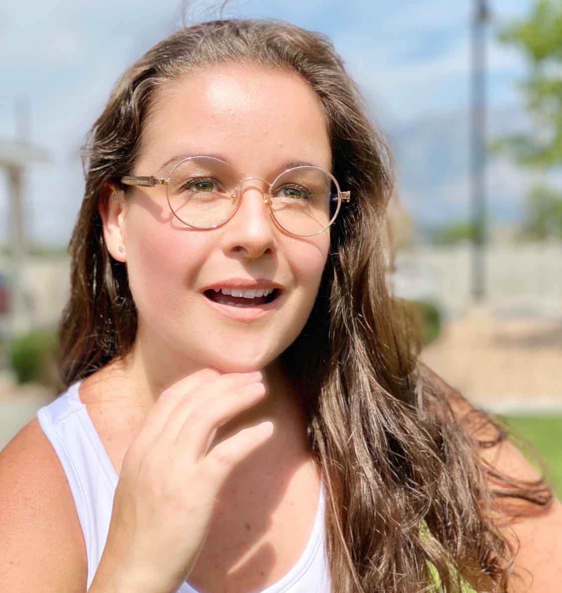 Woman wearing Joy Rose Gold, Round Metal glasses in Rose Gold with a white shirt