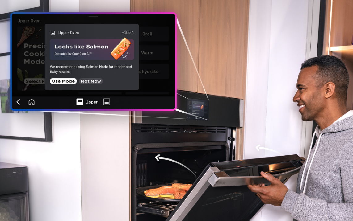 Person interacting with an oven while viewing a digital display.