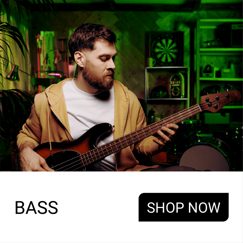 Man playing bass guitar in a colorful music studio setting.