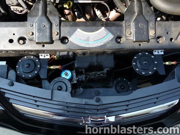 Engine bay front grille install four black train horn trumpets blue solenoid valve Mike's 2004 Chevrolet Impala Conductor's Special 544 Nightmare Edition HornBlasters customer install gallery photo 2