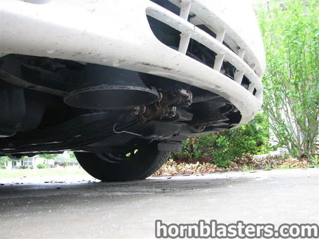 Large black train horn tucked behind front bumper low angle 2001 Toyota Corolla Nathan AirChime K5LA gallery photo 6