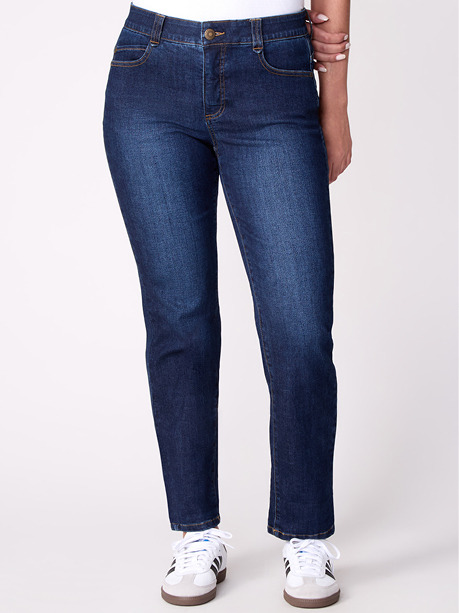 Woman wearing dark blue jeans and white sneakers.