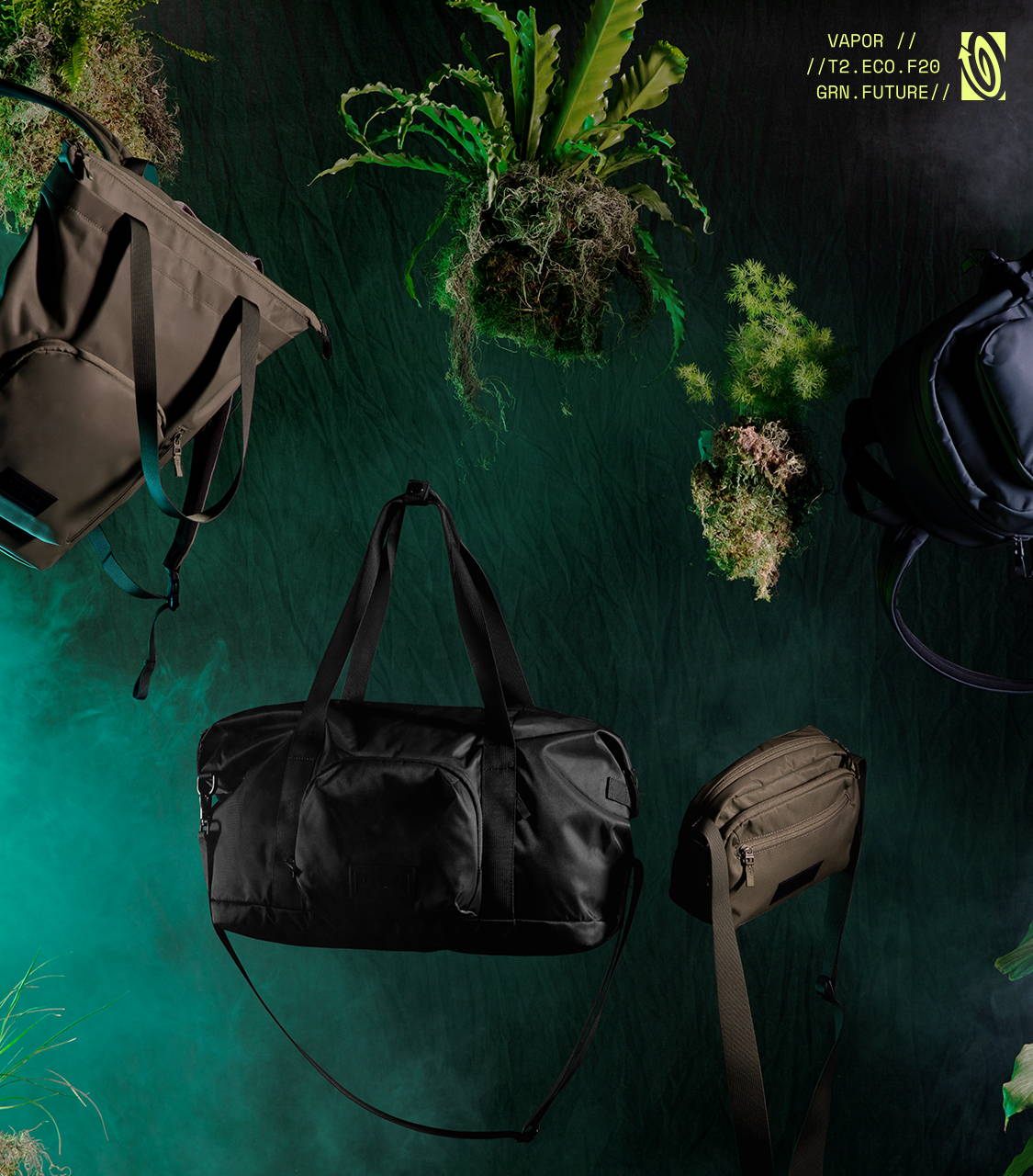 Image of Vapor Collection products floating in a dark room with mist in the background. The Vapor Tote, Vapor Duffel, Vapor Crossbody, are all featured with plants also floating. Copy reads: VAPOR // // T2.ECO.F20 GRN.FUTURE //