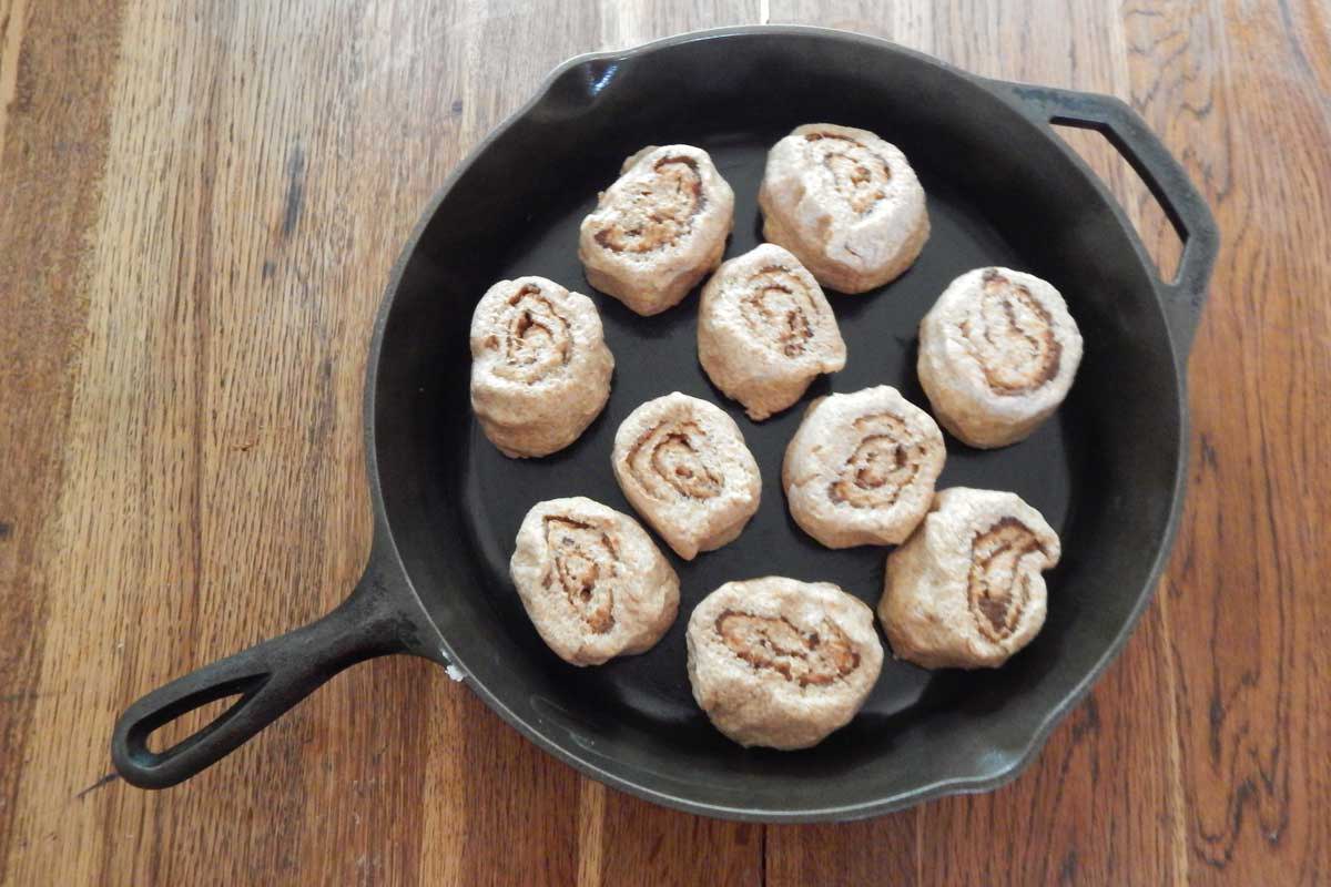 Cast iron skiller with cut pieces of cinnamon rolls