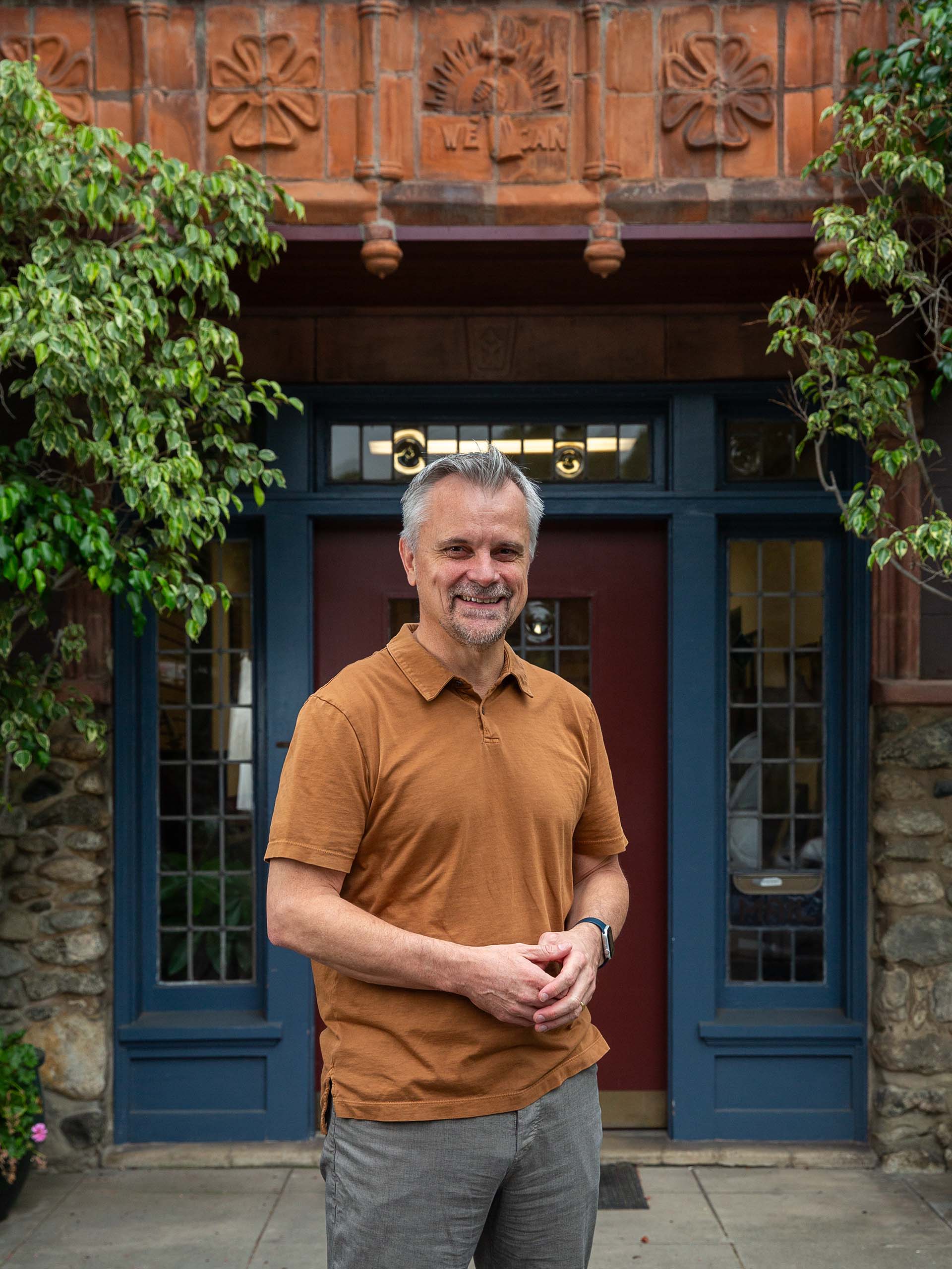 A portrait of David Judson outside the front door of the Judson Studios stained glass workshop.