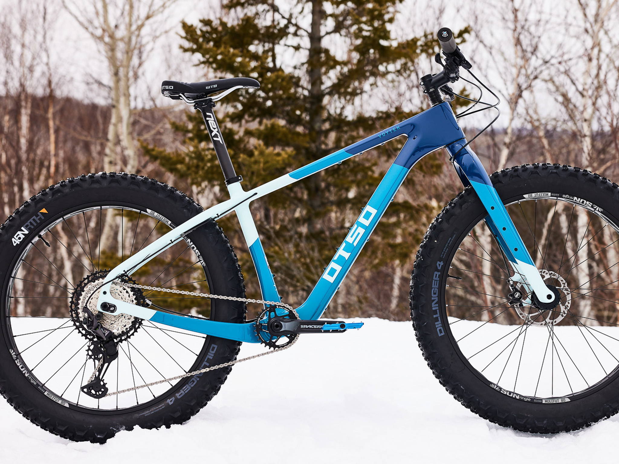 Blue Otso Voytek 2 fat bike pictured on snow in the woods.