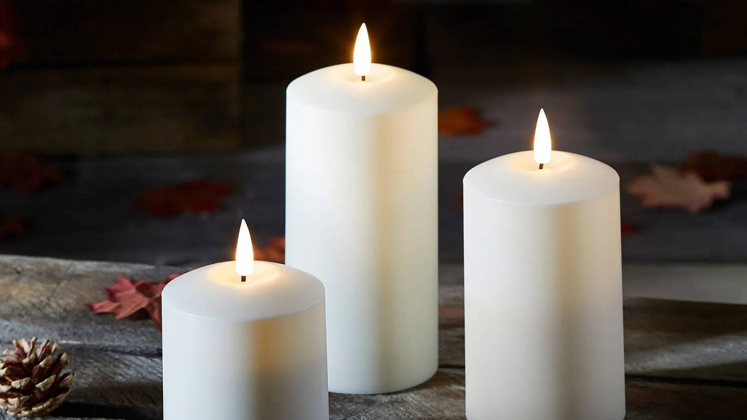 Outdoor TruGlow candle trio styled outdoors in autumnal setting 