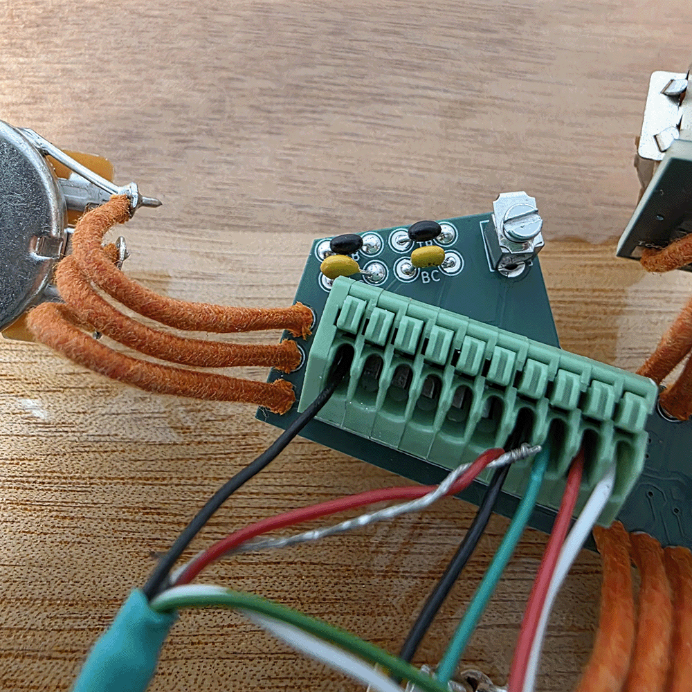 Close-up of electronic components with wires and connectors on a wooden surface.