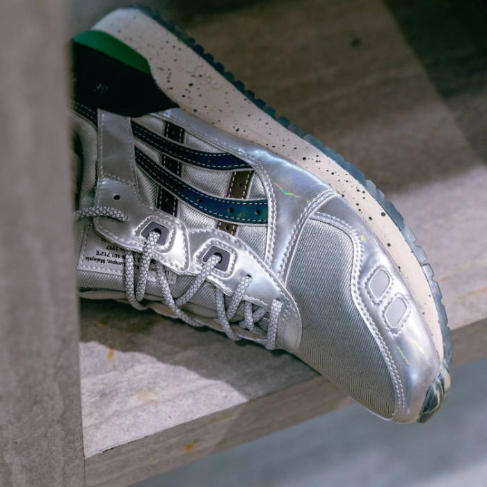 close up of silver and green asics shoe