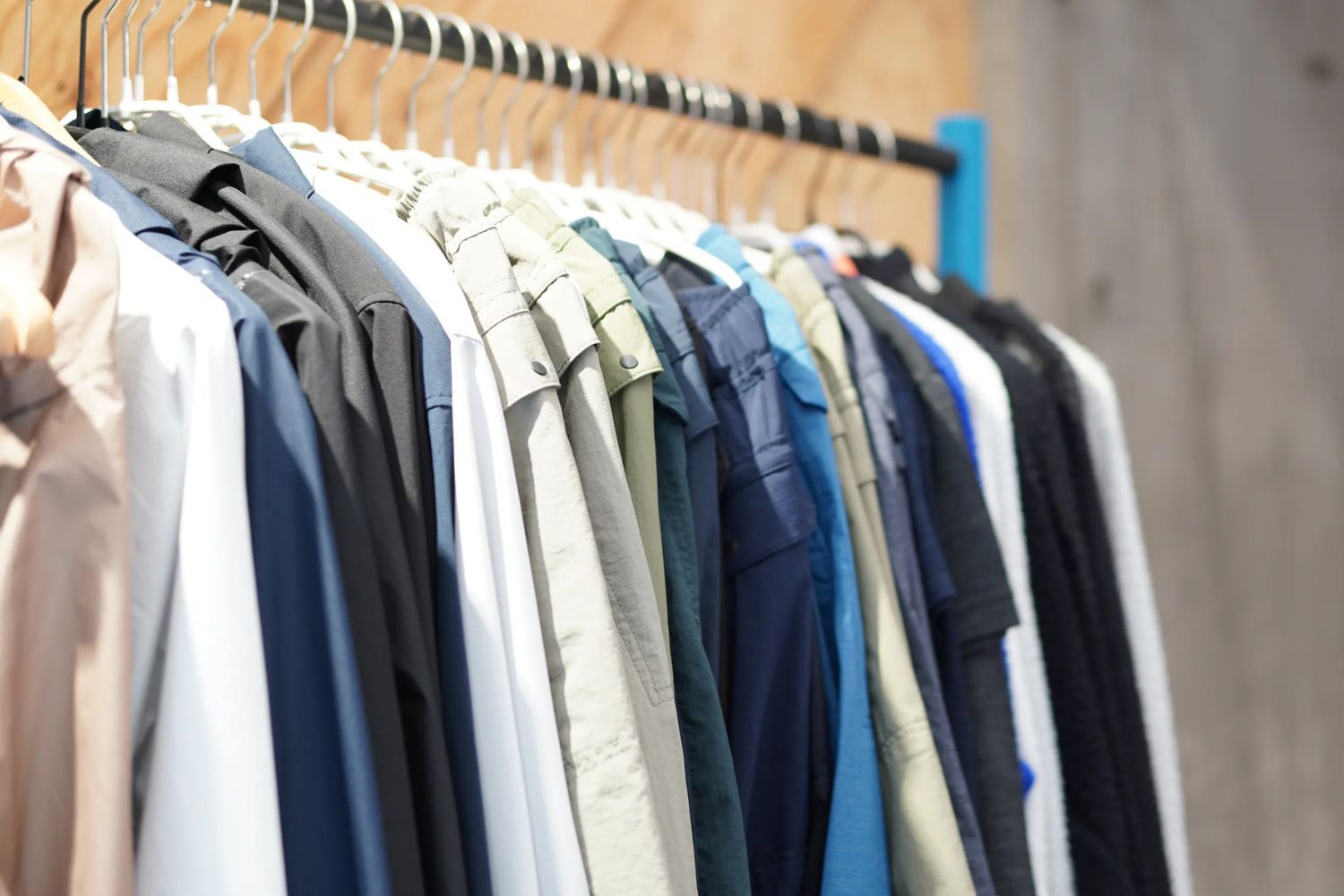 A rack of various colored shirts and blouses hanging neatly.