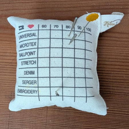 sewing machine needles on a needle sorting pincushion