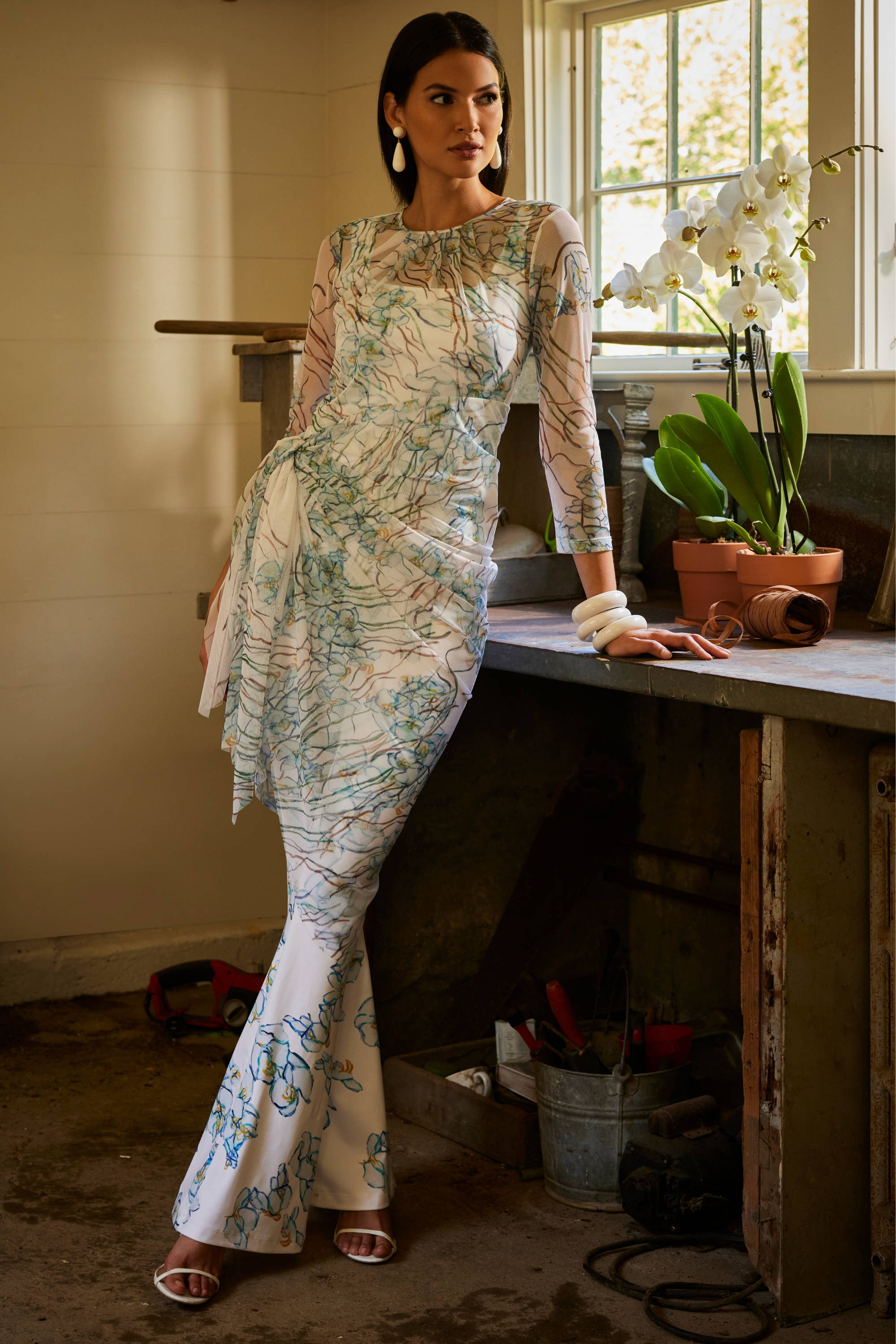 Woman wearing mesh floral topper over stretc knit tank top and pants in a greenhouse by Ala von Auersperg for spring 2024