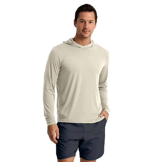 Man wearing a light hoodie and shorts, posing casually.